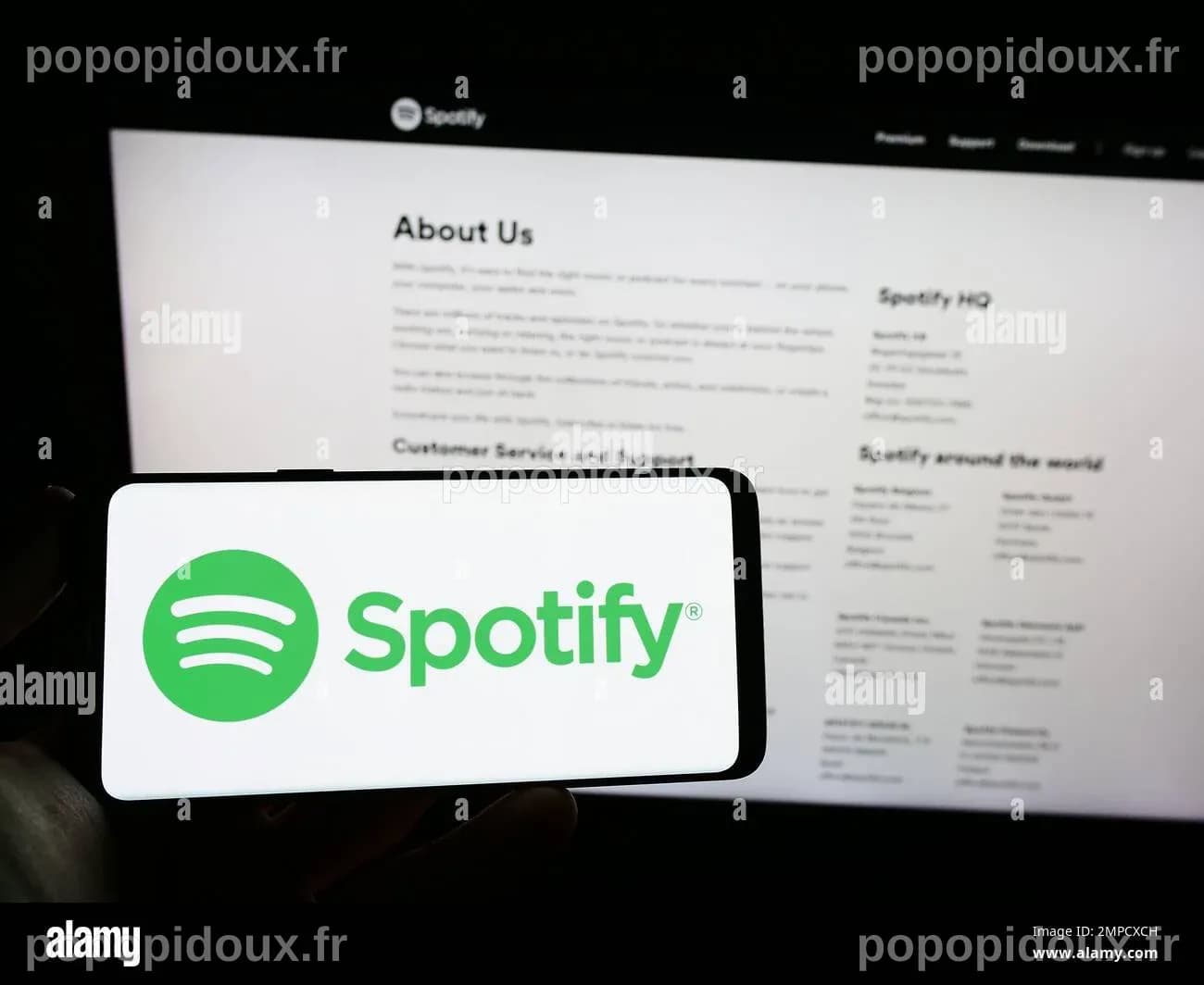 Person holding cellphone with logo of music streaming company Spotify ...